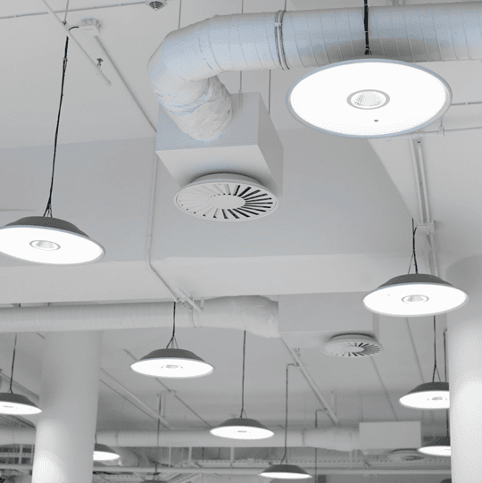 View of the ceiling in a commercial building showing light fixtures and AC vents